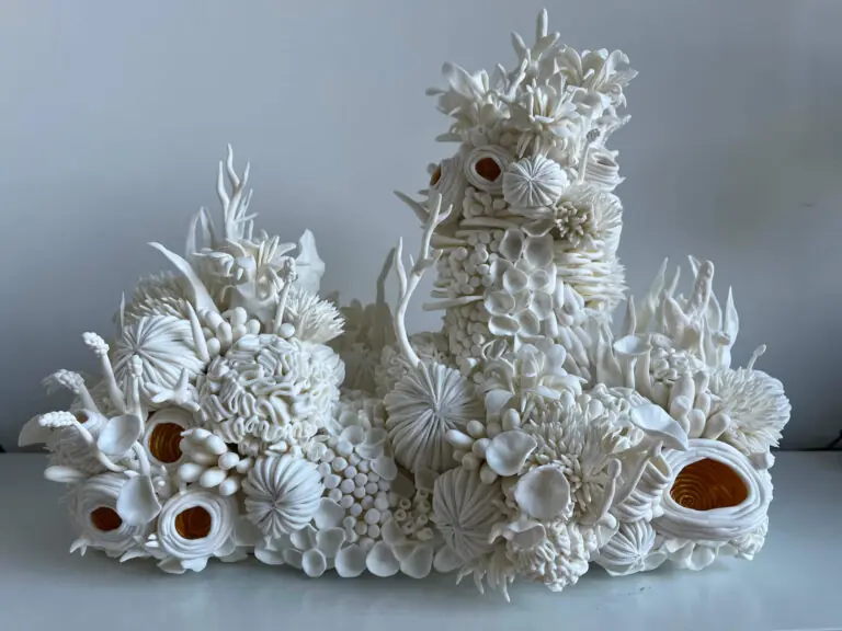 Abstract white sculptural installation composed of organic, coral-like ceramic forms.