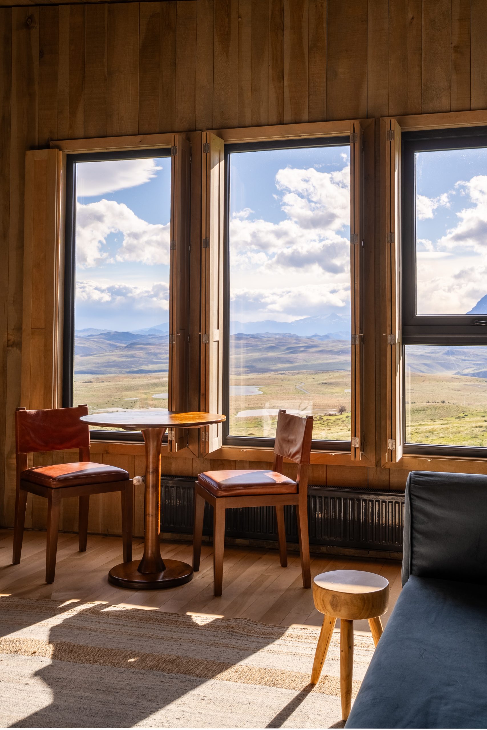 Interior of a luxurious stand-alone villa at Awasi Patagonia in Chile, featuring contemporary design inspired by traditional Patagonian shelters with native wood accents. The villa, elevated on stilts for privacy, offers stunning views of Torres del Paine and Lake Sarmiento, and includes a private guide, 4x4 vehicle, and all-inclusive personalized services for an immersive Patagonian wilderness experience.