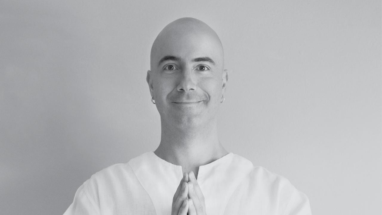 Satyanatha, monk and meditation guide, in a serene black-and-white portrait.