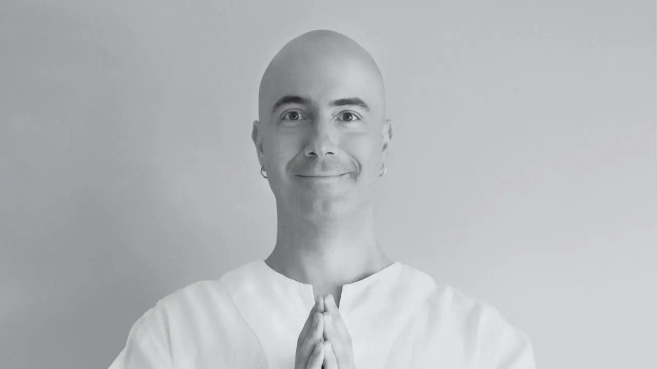 Satyanatha, monk and meditation guide, in a serene black-and-white portrait.