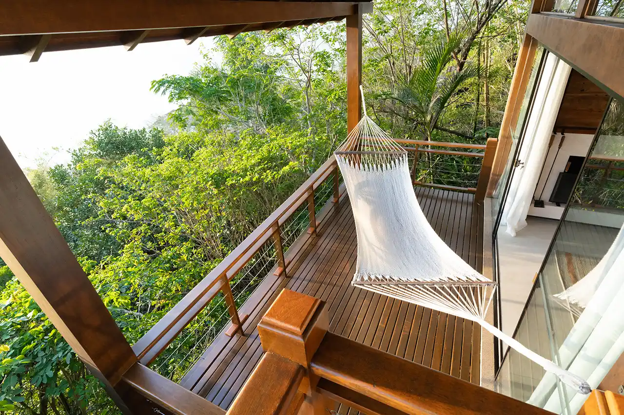 Hammock on a wooden balcony overlooking a lush green rainforest at Awasi Iguazu