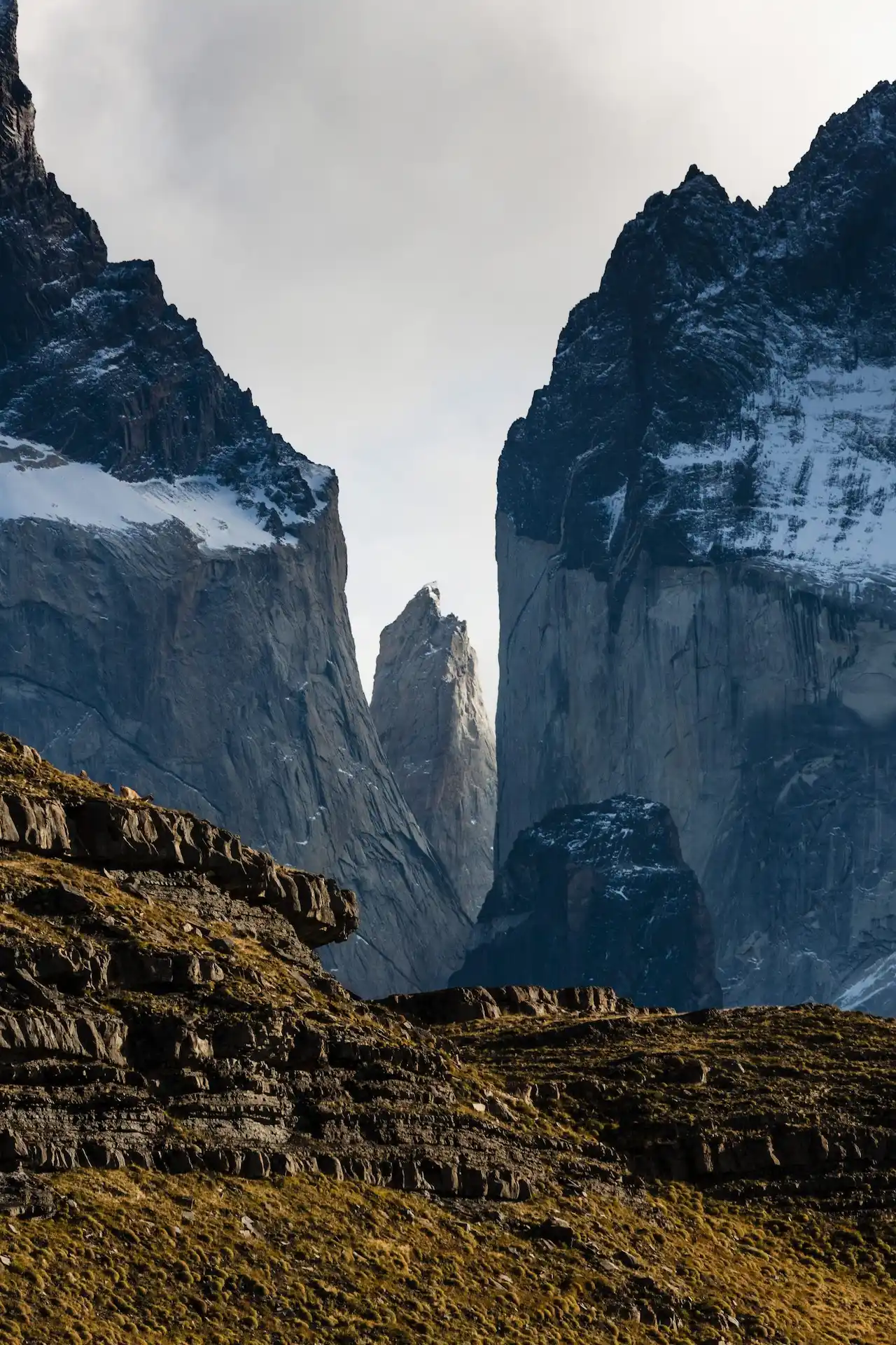 Dramatic mountain landscape with towering cliffs and snow-dusted peaks