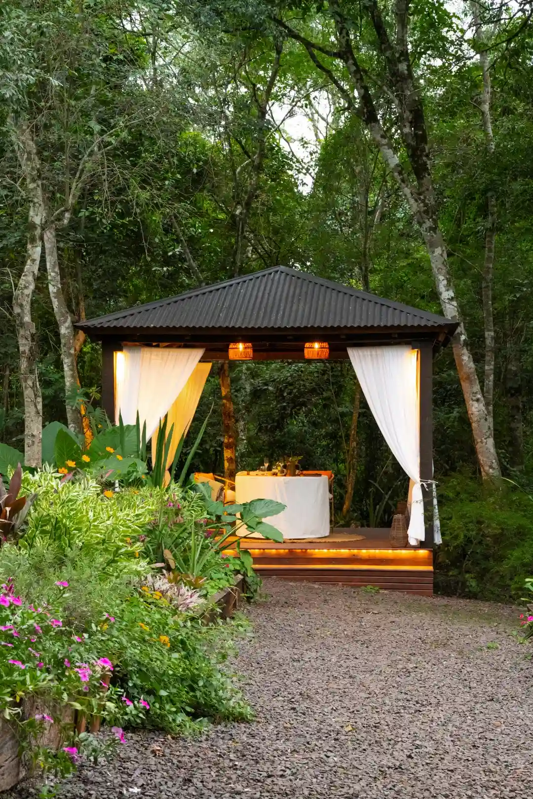 Romantic outdoor dining gazebo set in lush greenery with soft ambient lighting