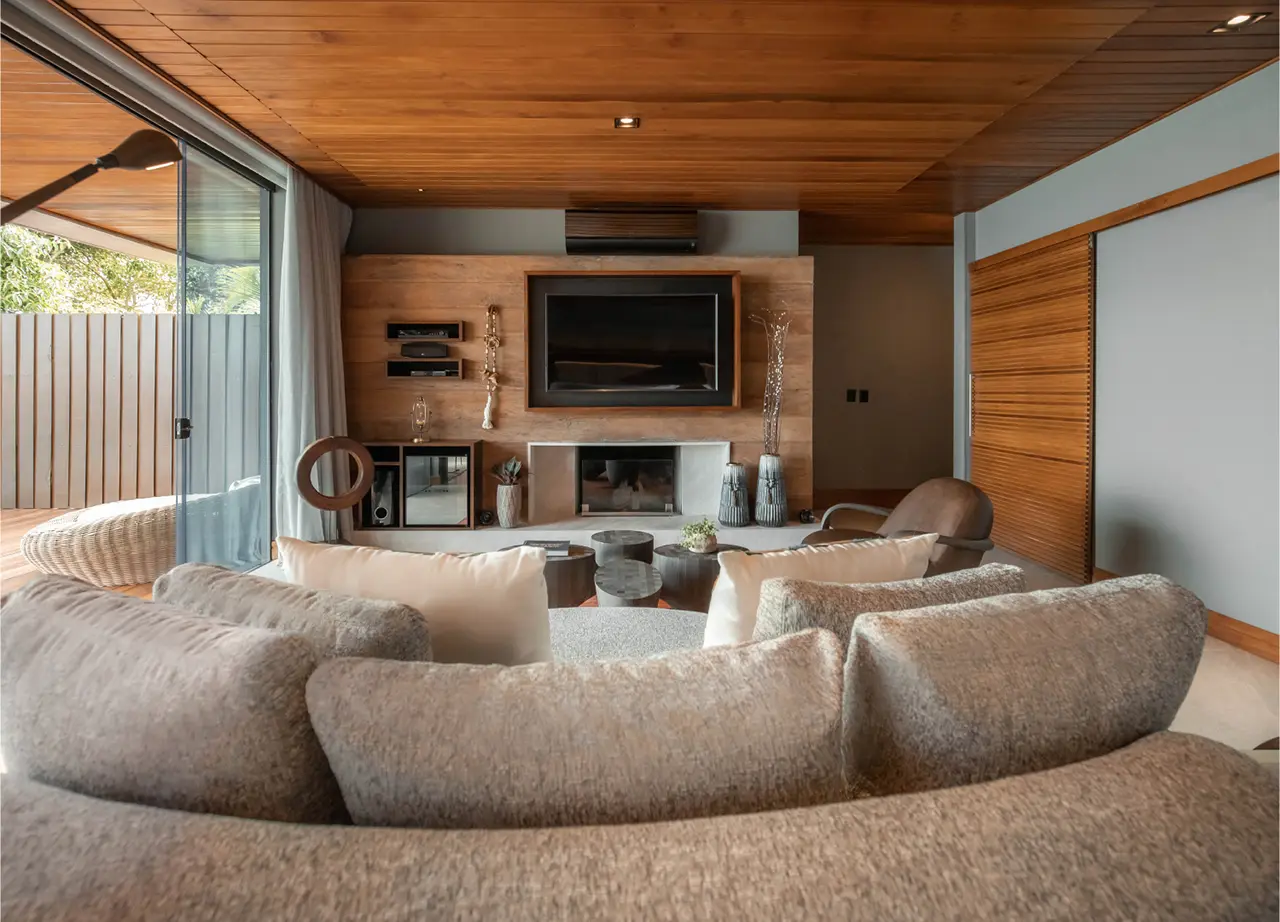Modern living room with fireplace large sofa wooden ceiling and sliding glass doors creating a warm cozy atmosphere