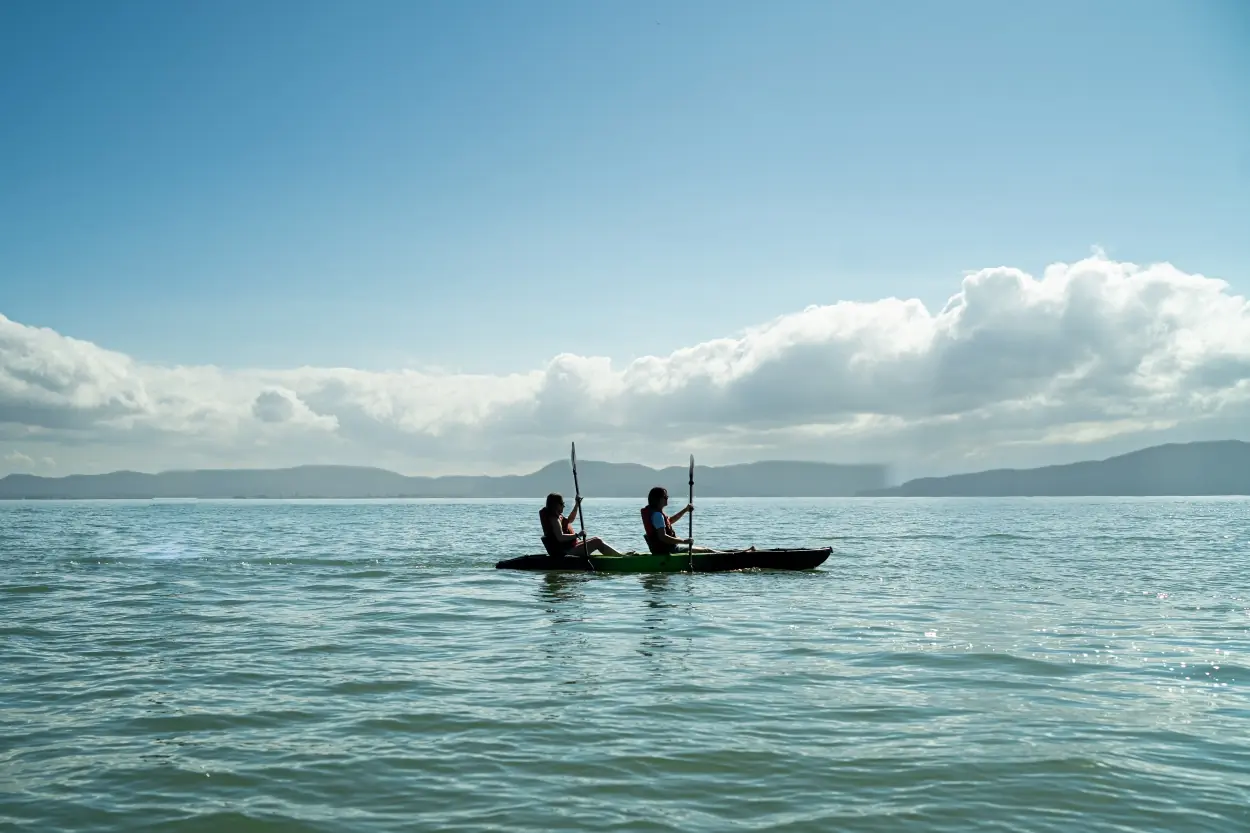 Two People Rowing A Canoe